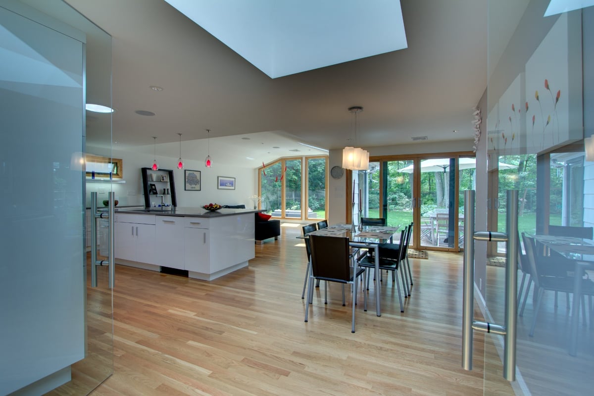 bright open kitchen and dining area with skylights and hardwood floors by PEGASUS Design-to-Build in Arlington, MA-optimized