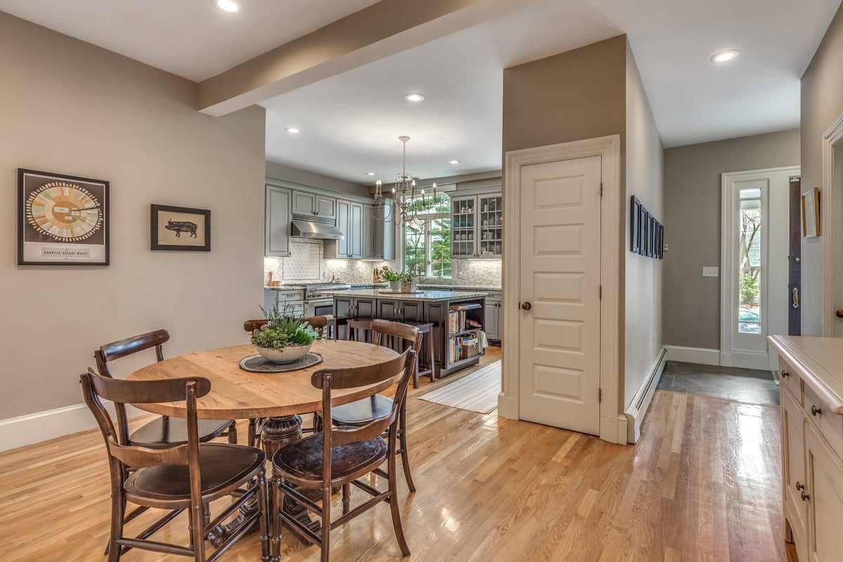 Bright kitchen and dining area addition in Winchester, MA by Pegasus Design-to-Build with gray cabinets, wood flooring, and island seating-optimized