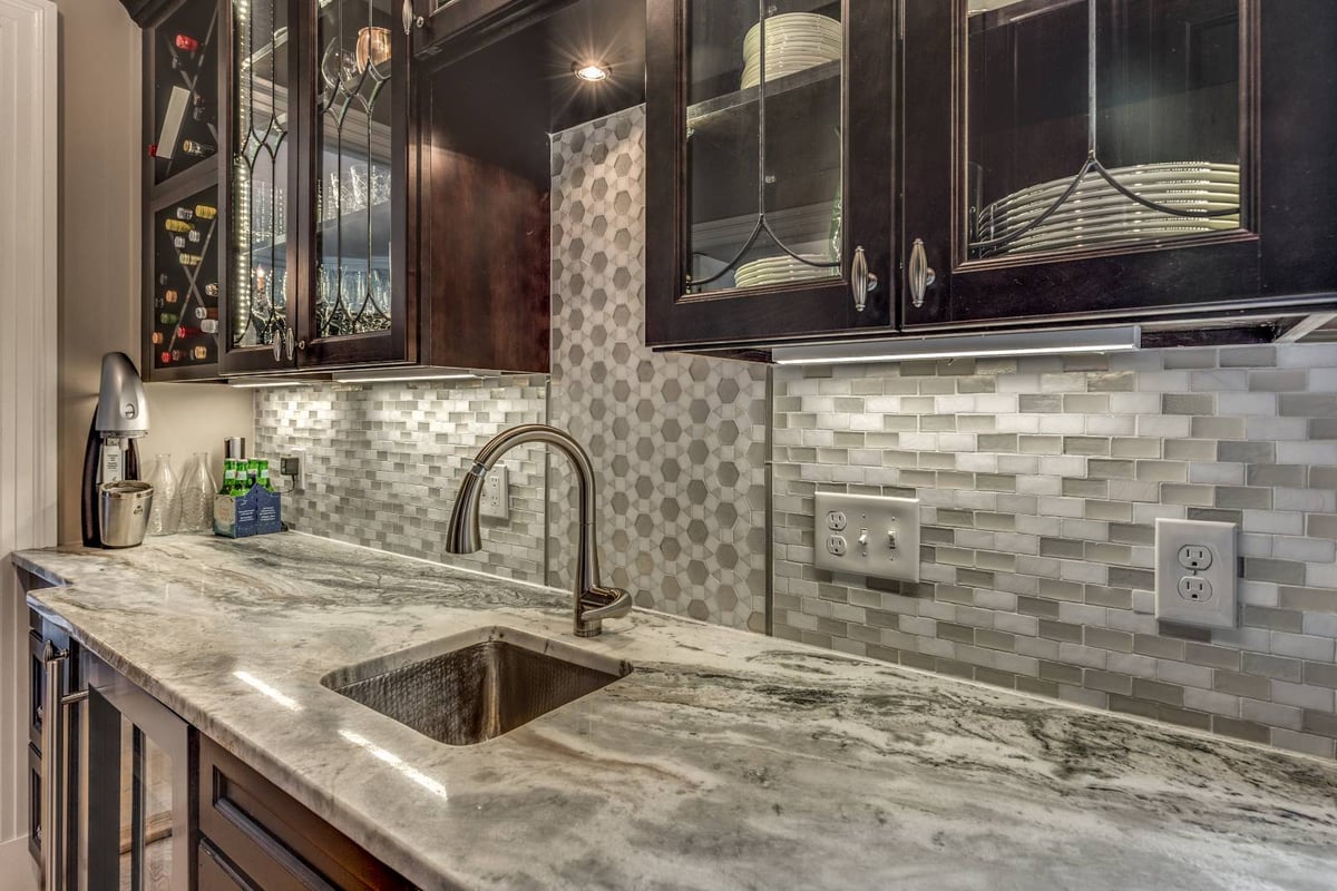 Close-up of custom pantry cabinetry in Winchester, MA by Pegasus Design-to-Build with marble counters and glass doors-optimized