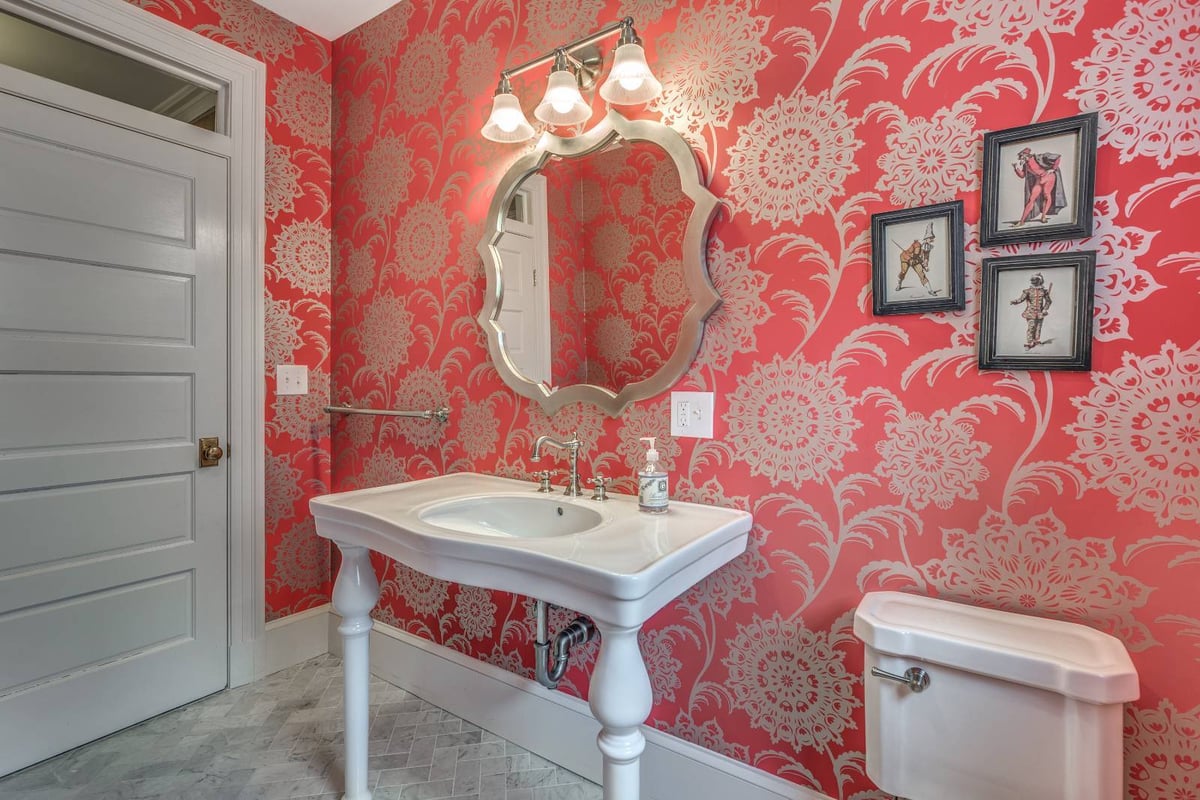 Close-up of powder room vanity in Winchester, MA by Pegasus Design-to-Build with patterned wallpaper and modern lighting-optimized