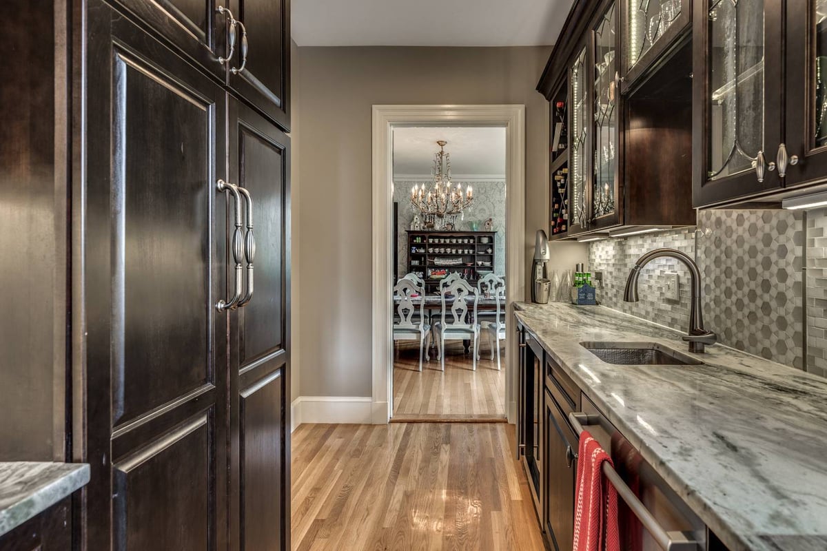 Galley-style pantry kitchen addition in Winchester, MA by Pegasus Design-to-Build with dark cabinetry and stone counters-optimized