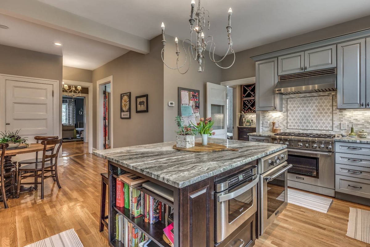 Kitchen island and dining area remodel in Winchester, MA by Pegasus Design-to-Build with stone countertops and wood flooring-optimized