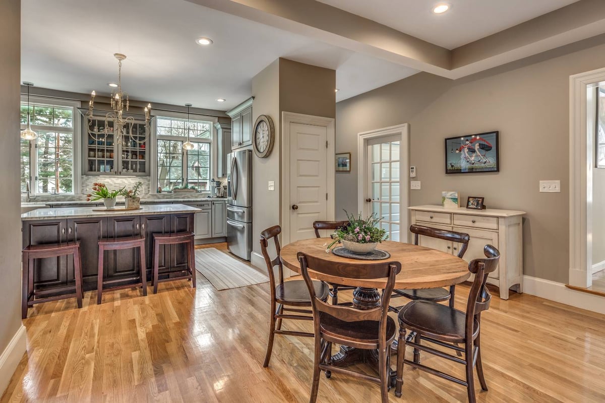 Open dining and kitchen renovation in Winchester, MA by Pegasus Design-to-Build with island seating and hardwood floors-optimized