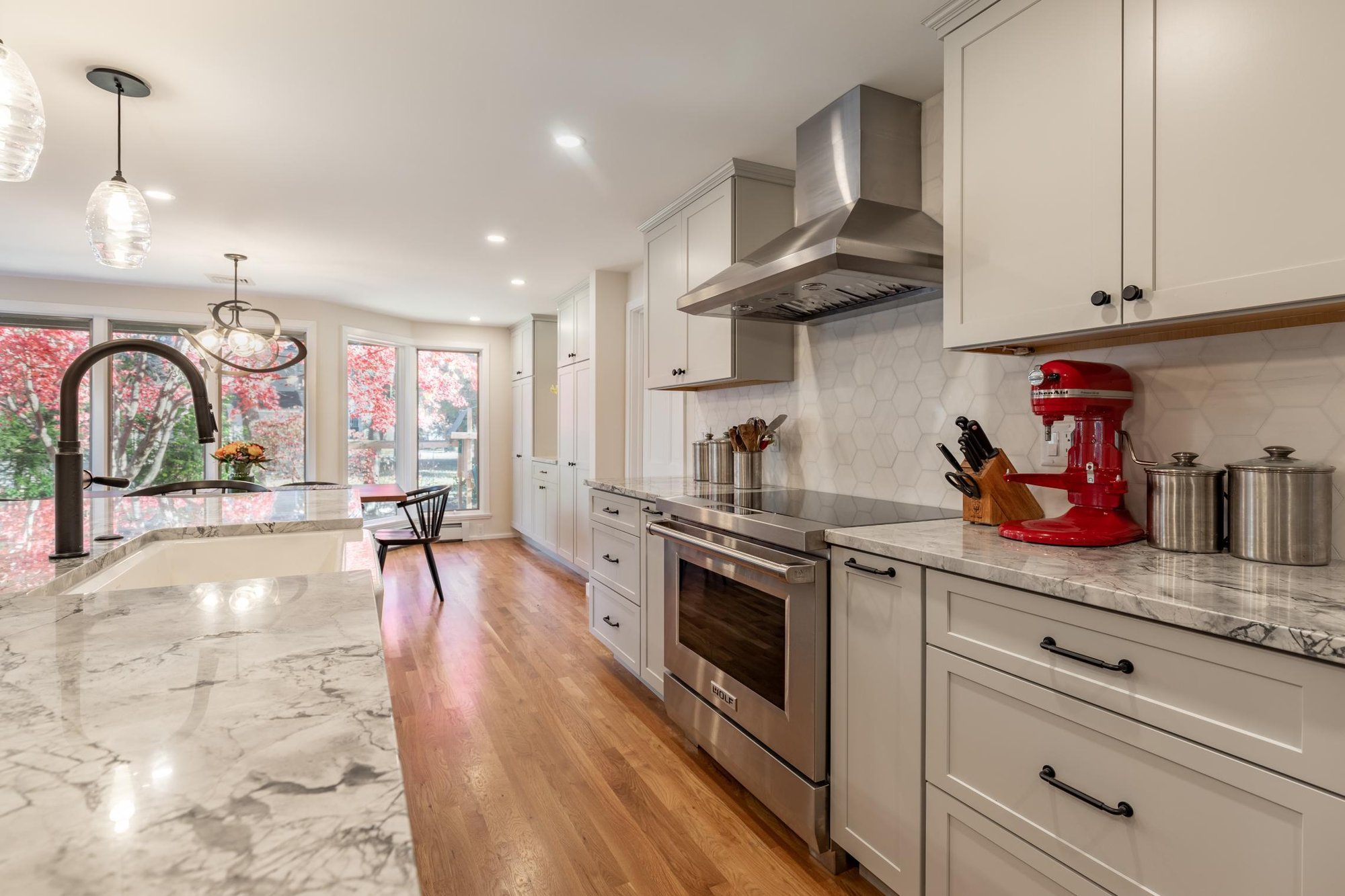 Long view of kitchen remodel with island and stainless steel appliances and white cabinetry by PEGASUS Design-To-Build Long view of kitchen remodel with island and stainless steel appliances and white cabinetry by PEGASUS Design-To-Build