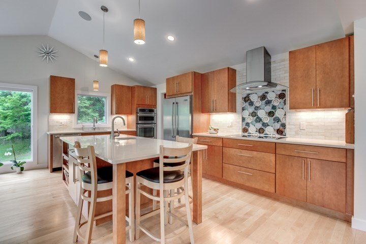 warm kitchen design with pendant lighting and island workspace by PEGASUS Design-to-Build in Lexington, MA