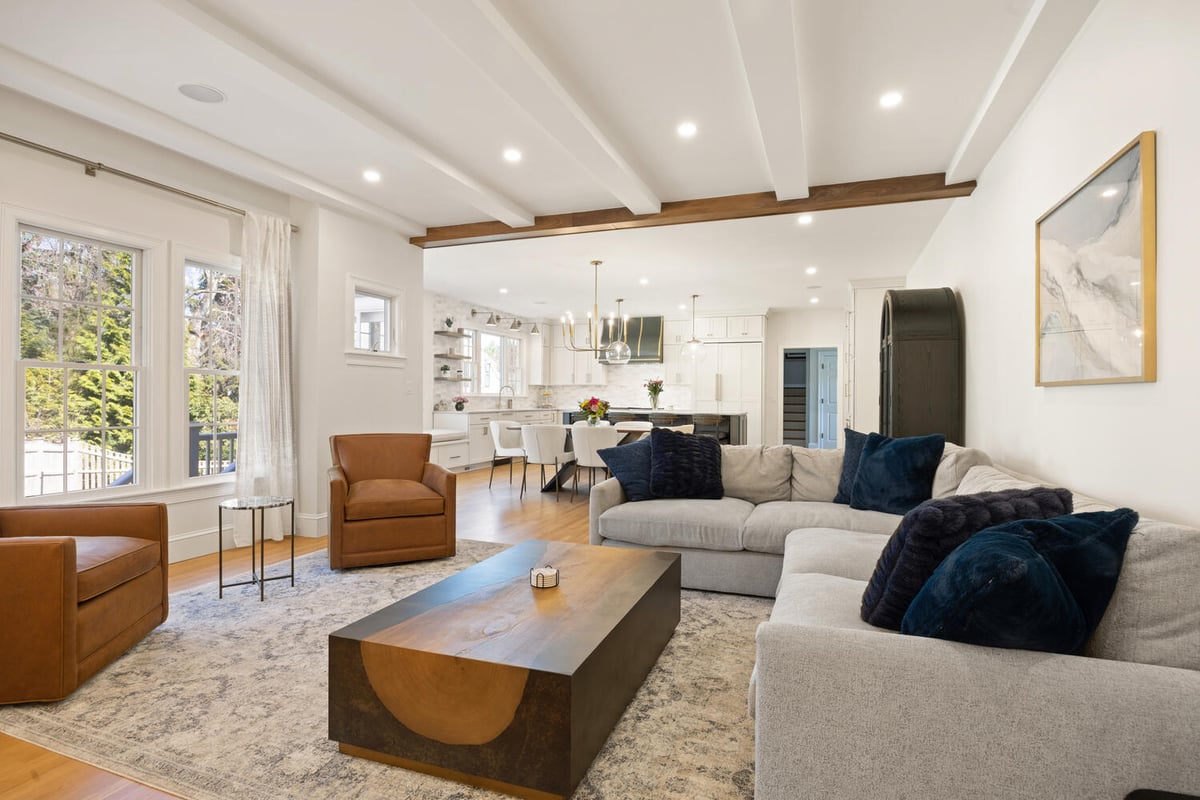 bright living room flowing into kitchen with wood beam detail by PEGASUS Design-to-Build in Lexington, MA
