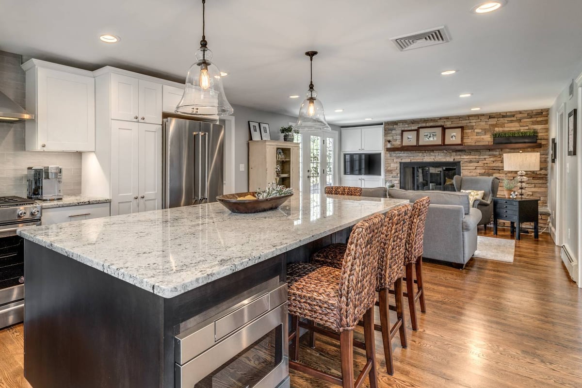 Kitchen island and living room view in Lexington, MA remodel by PEGASUS Design-to-Build with open layout-optimized