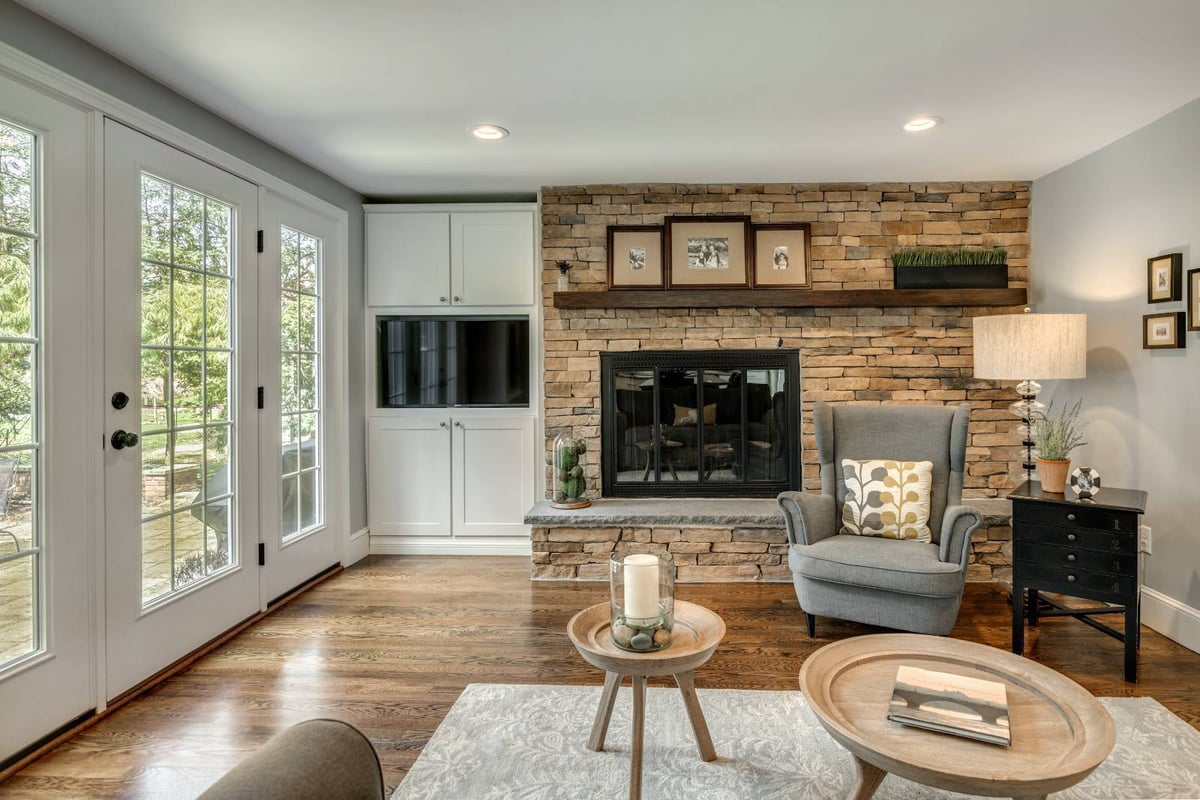 Living room with stone fireplace in Lexington, MA remodel by PEGASUS Design-to-Build featuring built-in cabinetry-optimized