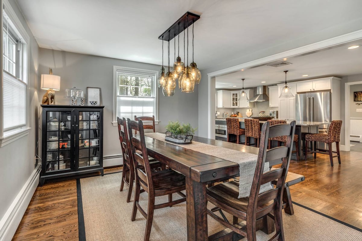 Open dining and kitchen remodel in Lexington, MA by PEGASUS Design-to-Build with custom lighting and hardwood floors-optimized
