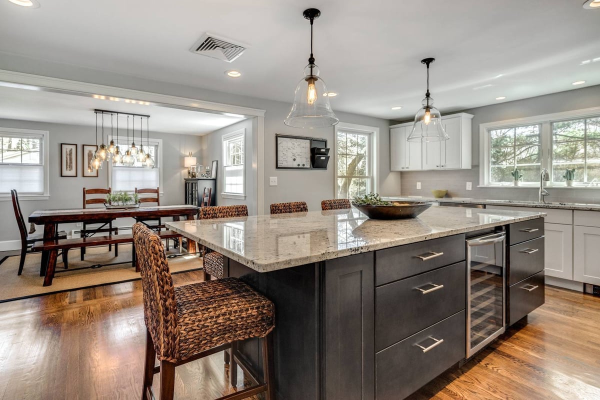 Open kitchen and dining layout in Lexington, MA remodel by PEGASUS Design-to-Build with large central island-optimized