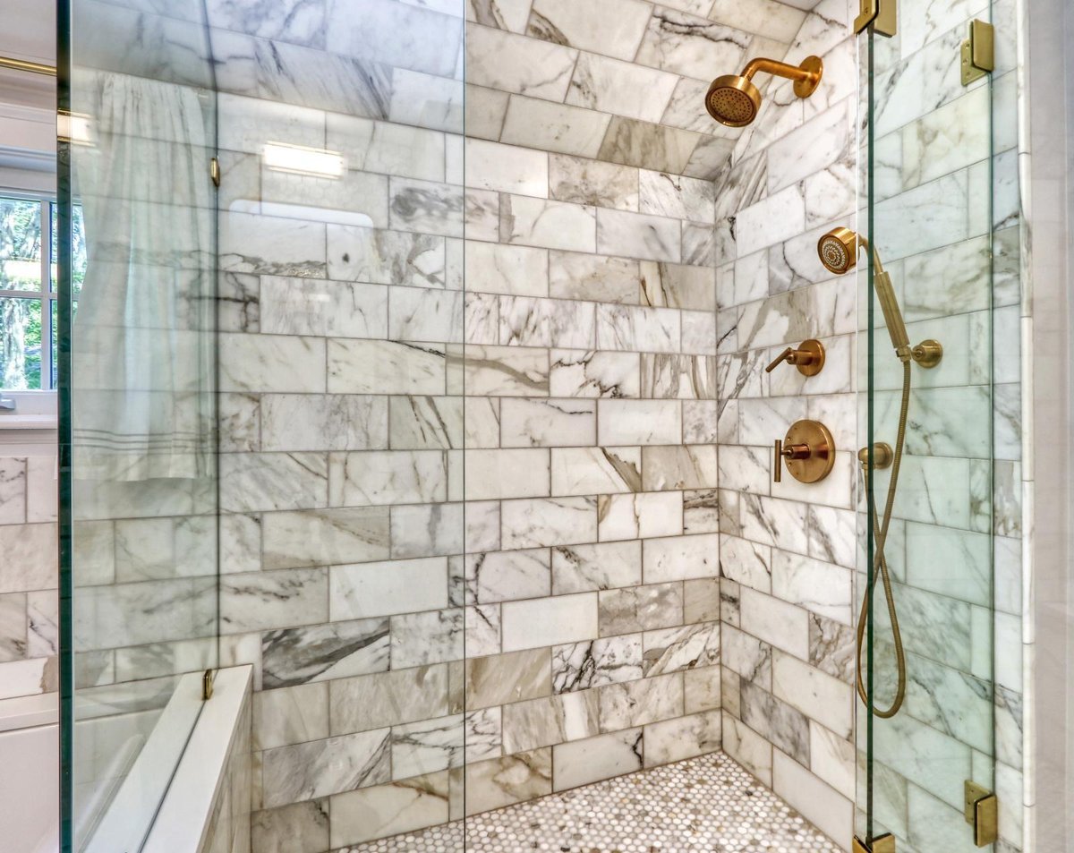 Walk-in shower remodel in Melrose, MA by PEGASUS Design-to-Build with marble tile and brass shower fixtures.-optimized