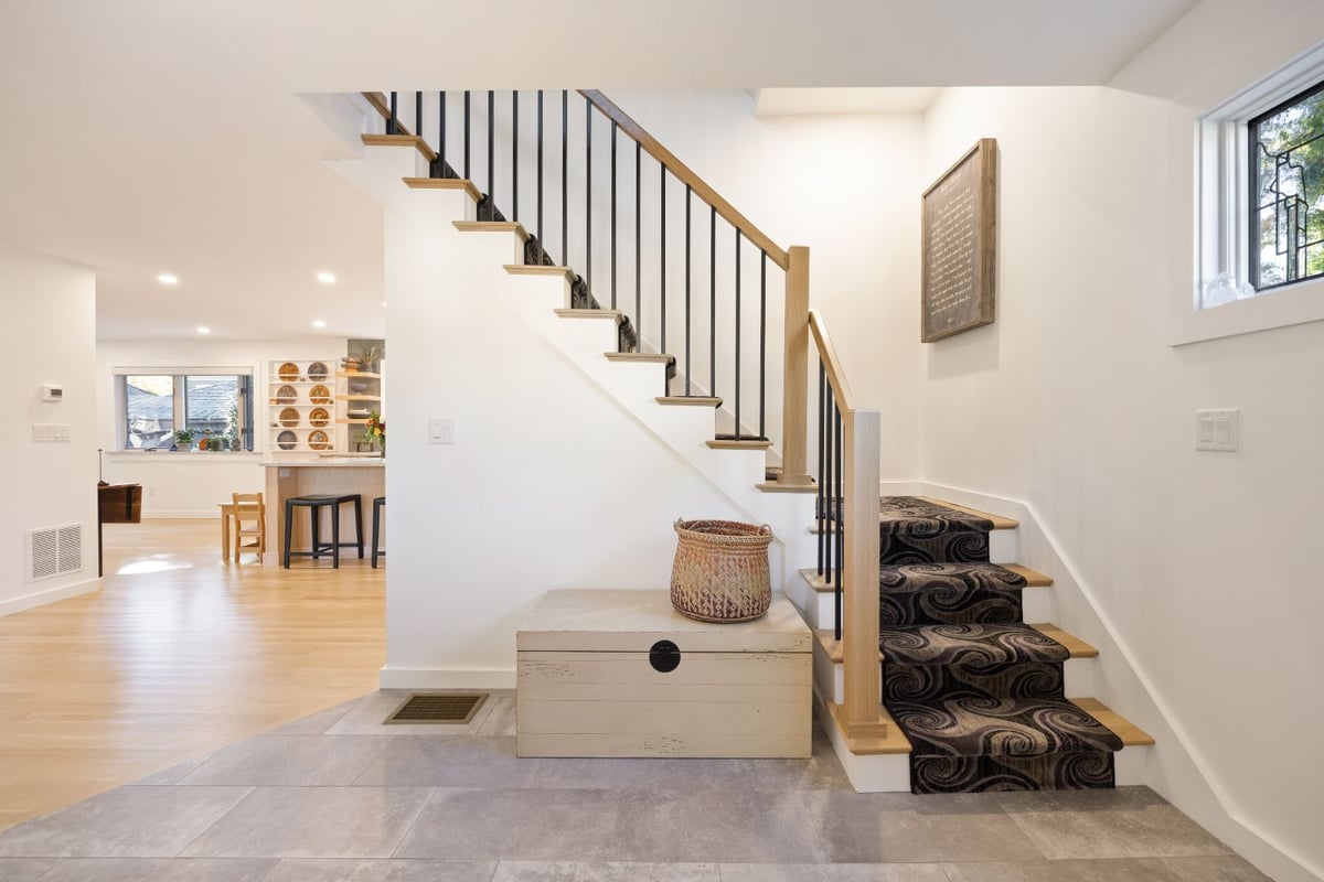Bright entryway with modern staircase and wood accents by PEGASUS Design-to-Build in Melrose, MA kitchen and addition renovation-optimized
