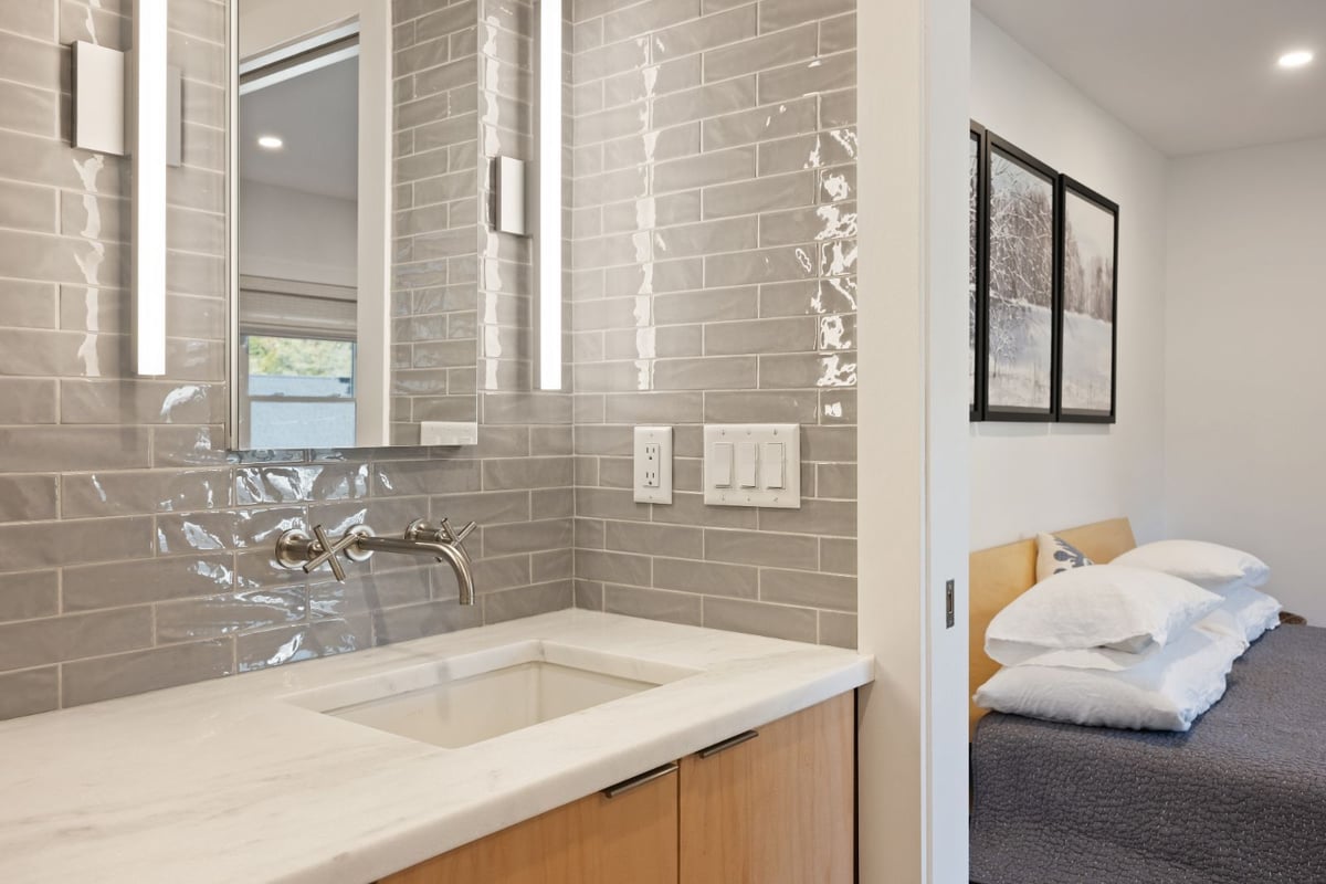 Modern bathroom vanity with wall-mounted faucet and tile backsplash by PEGASUS Design-to-Build in Melrose, MA kitchen and addition renovation-optimized