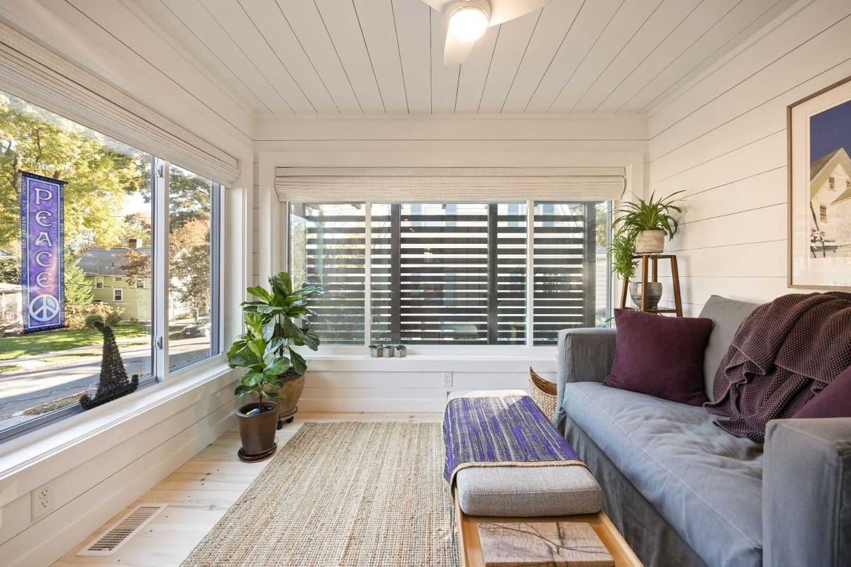 Sunroom addition with cozy seating and large windows by PEGASUS Design-to-Build in Melrose, MA kitchen and addition renovation-optimized