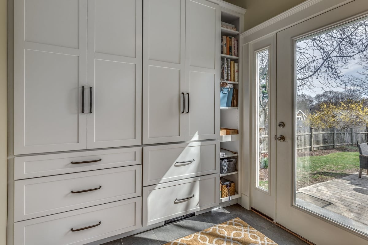 Built-in storage cabinets in Melrose MA mudroom remodel by PEGASUS Design-to-Build with custom shelving-optimized