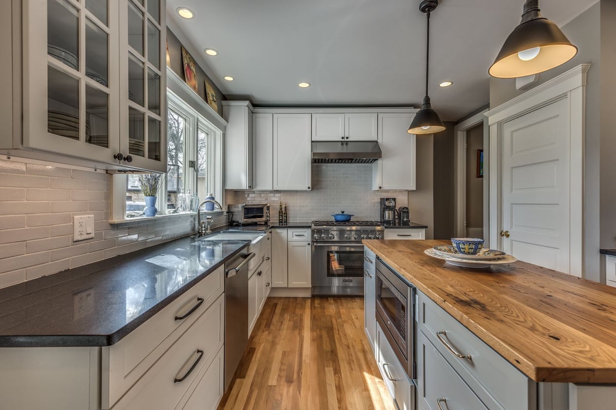 Galley-style kitchen renovation in Melrose MA by PEGASUS Design-to-Build with wood island and farmhouse sink-optimized