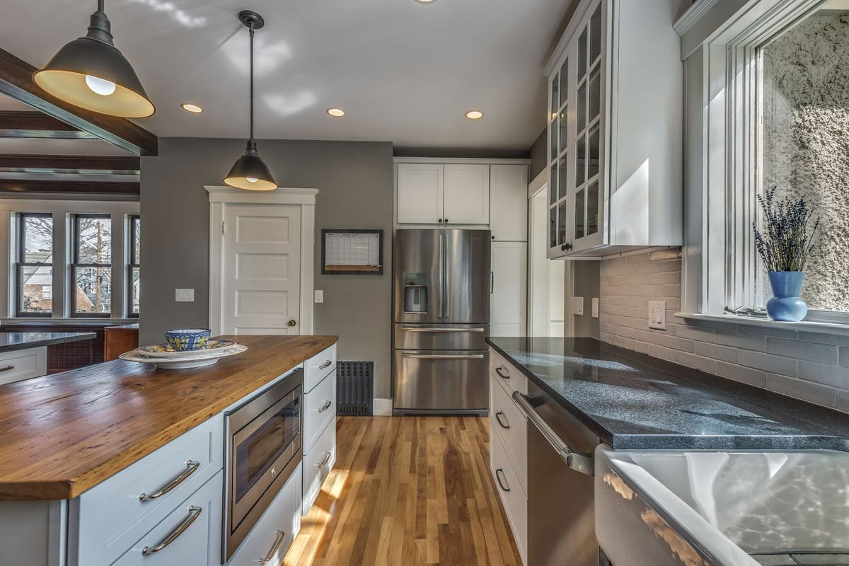 Kitchen island and refrigerator view in Melrose MA remodel by PEGASUS Design-to-Build with stainless steel appliances-optimized