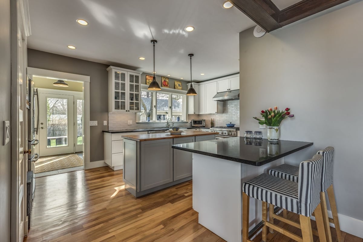 Kitchen peninsula seating area in Melrose MA remodel by PEGASUS Design-to-Build with bar stools and island-optimized