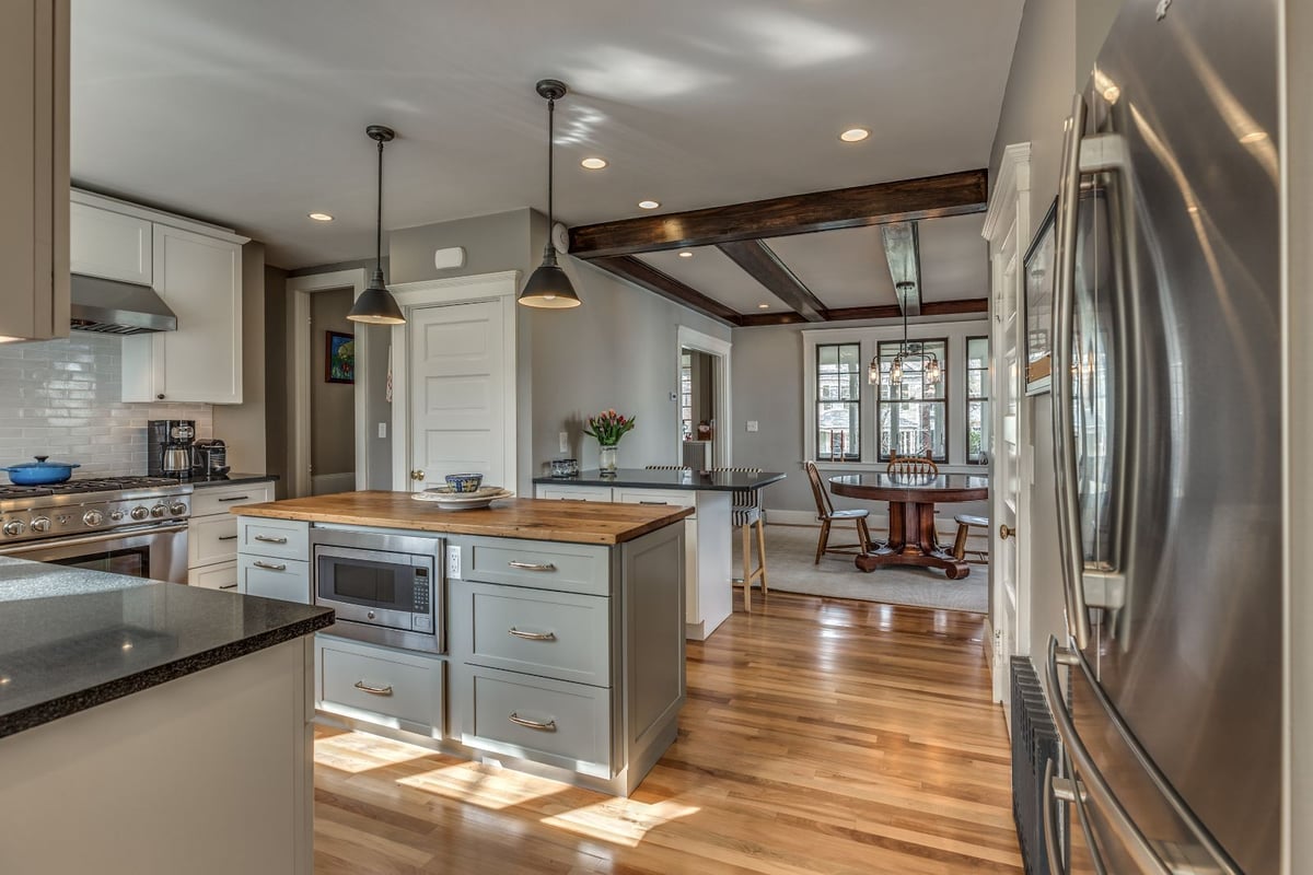 Open kitchen and dining area remodel in Melrose MA by PEGASUS Design-to-Build with wood island and hardwood floors-optimized
