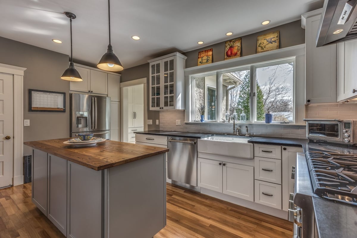 Updated kitchen in Melrose MA by PEGASUS Design-to-Build showcasing farmhouse sink, subway tile backsplash, and wood island-optimized
