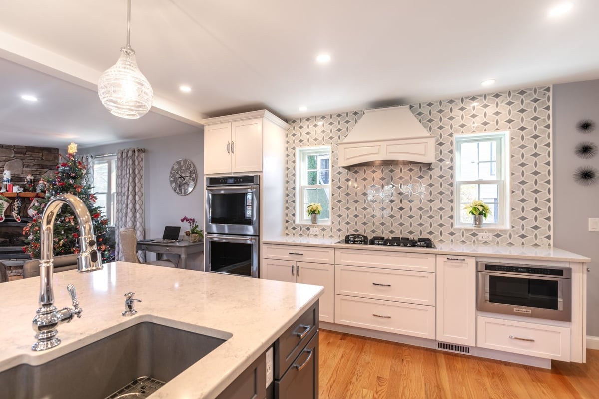 open kitchen with view of fireplace and living space in Melrose MA remodel by PEGASUS Design-to-Build-optimized