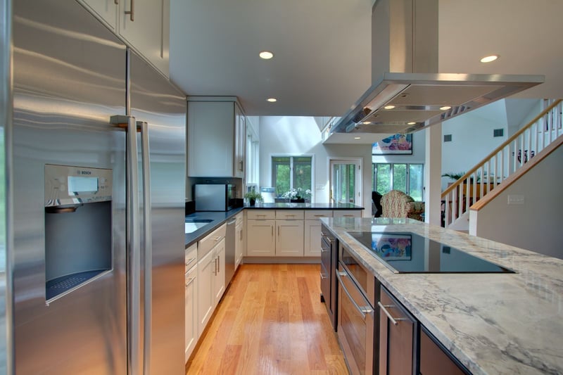 Open-concept kitchen featuring large island and stainless appliances in Wellesley, MA by PEGASUS Design-to-Build-optimized