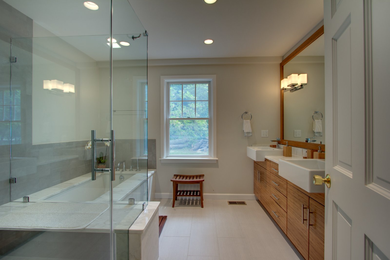 Modern bathroom renovation on the North Shore, MA by Pegasus Design-to-Build featuring dual sinks and glass shower