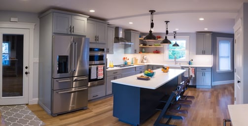 Renovated first-floor kitchen with navy island, gray shaker cabinets and stainless appliances in Arlington, MA