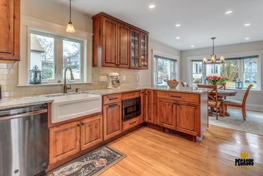 Remodeled kitchen with rustic alder cabinets, granite counters and farmhouse sink opening to the dining area in Arlington, MA