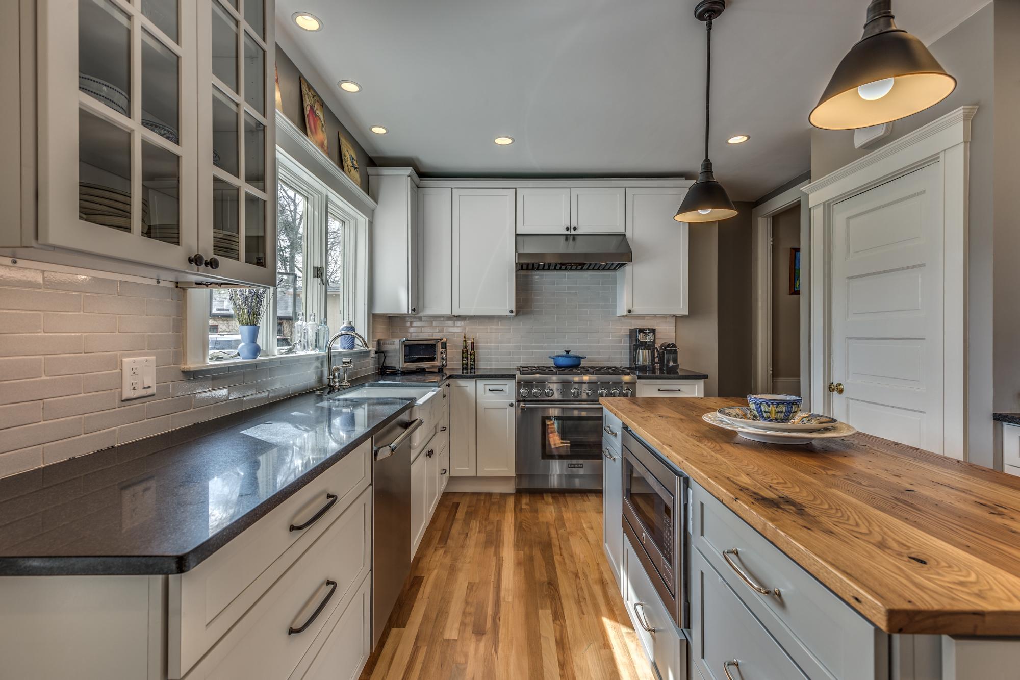 Galley-style kitchen renovation in Melrose MA by PEGASUS Design-to-Build with wood island and farmhouse sink-optimized