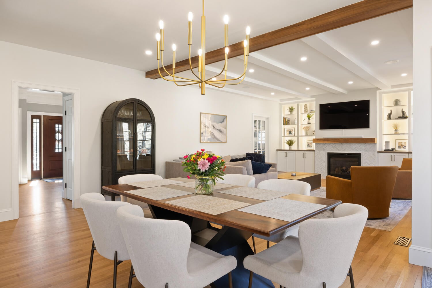 dining room with modern chandelier and open living space by PEGASUS Design-to-Build in Lexington, MA