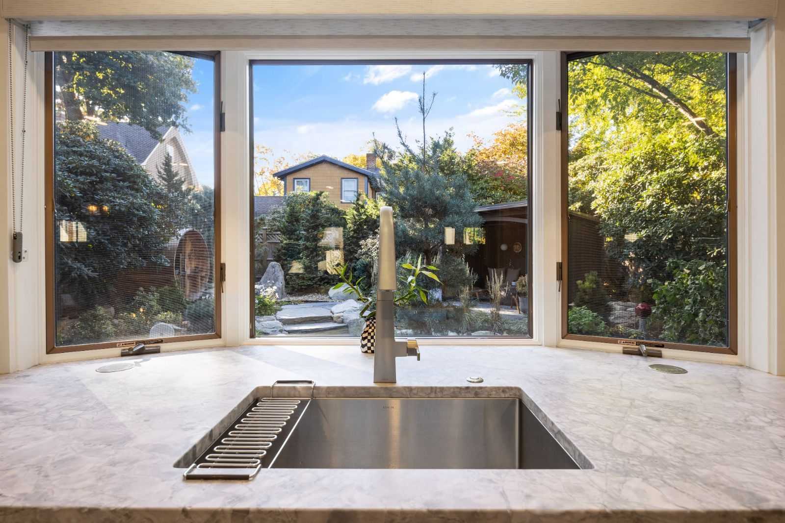 Kitchen sink with large windows overlooking landscaped backyard by PEGASUS Design-to-Build in Melrose, MA kitchen and addition renovation-optimized