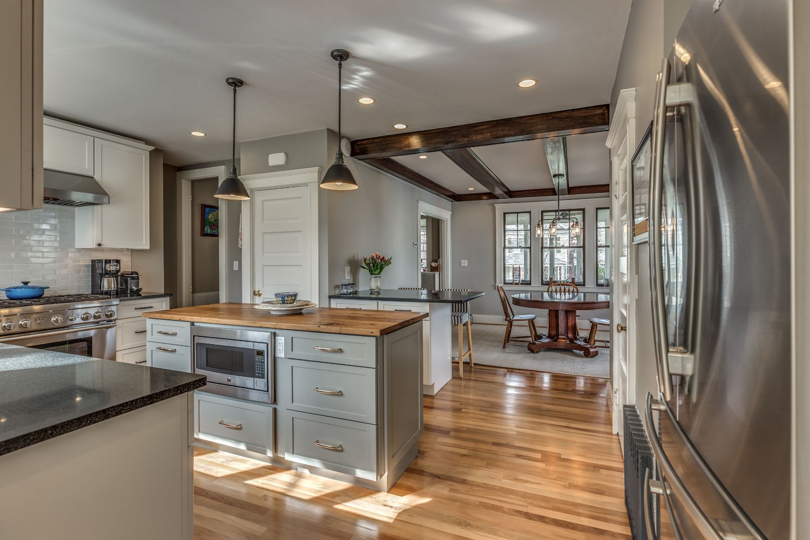 Open kitchen and dining area remodel in Melrose MA by PEGASUS Design-to-Build with wood island and hardwood floors-optimized