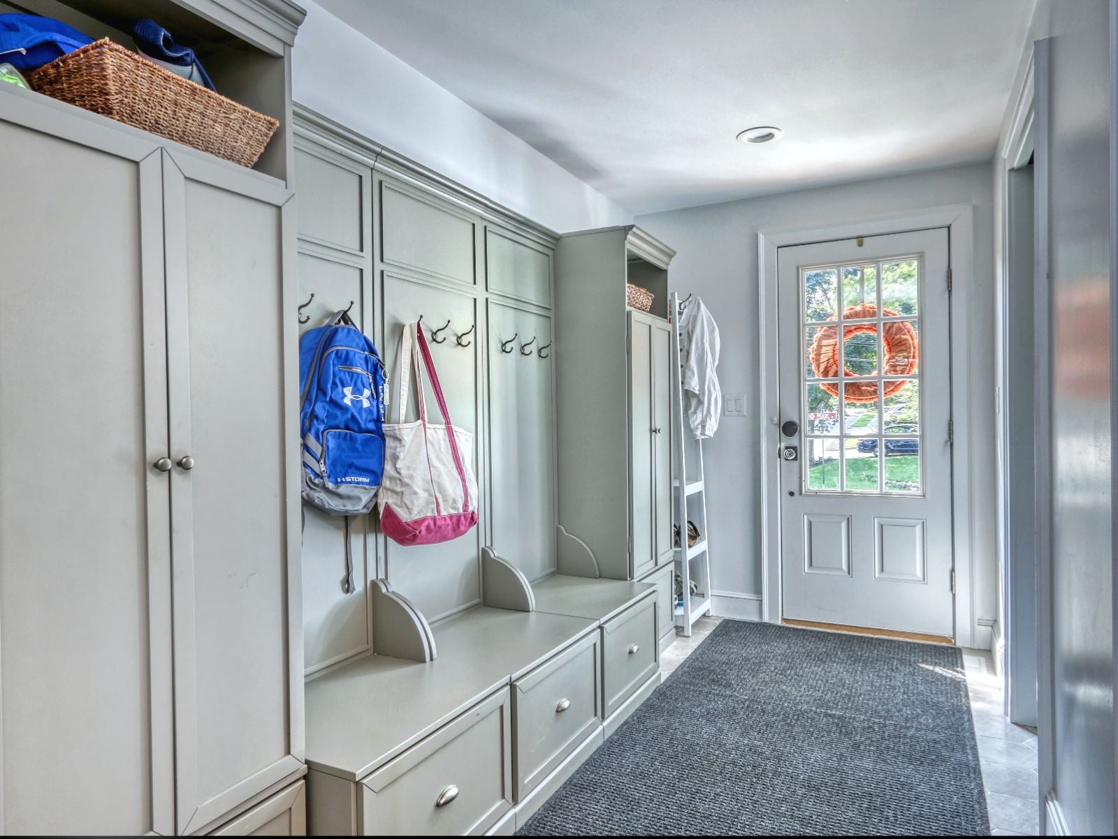 Custom mudroom addition in Melrose, MA by Pegasus Design-to-Build with built-in storage, bench seating, and entry door-optimized