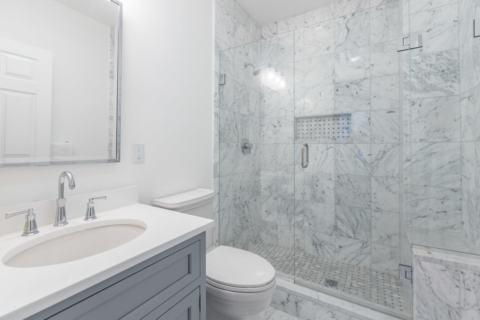 Modern bathroom remodel in Boston, MA by Pegasus Design-to-Build featuring marble tile shower and glass enclosure-optimized