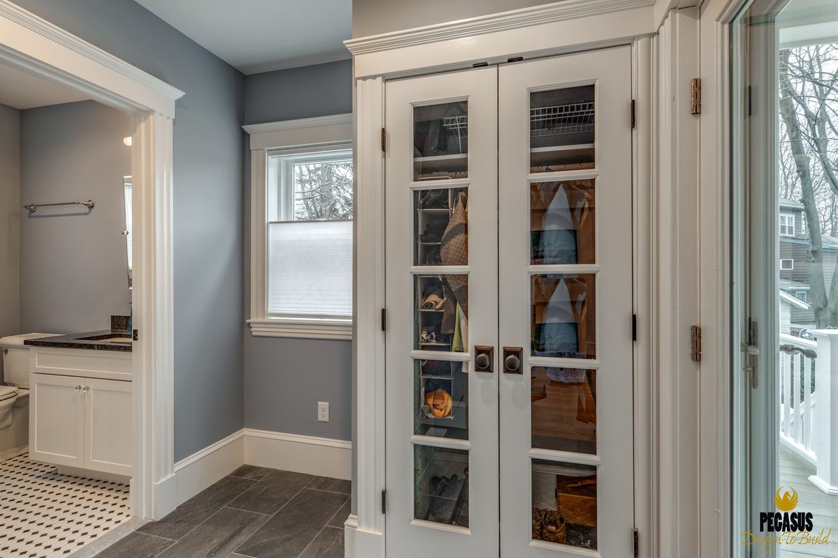 After: Back entry: a back door squeezed beside a tiny bath became a mudroom in the new addition, with glass-front closet doors and a full bath next to it.