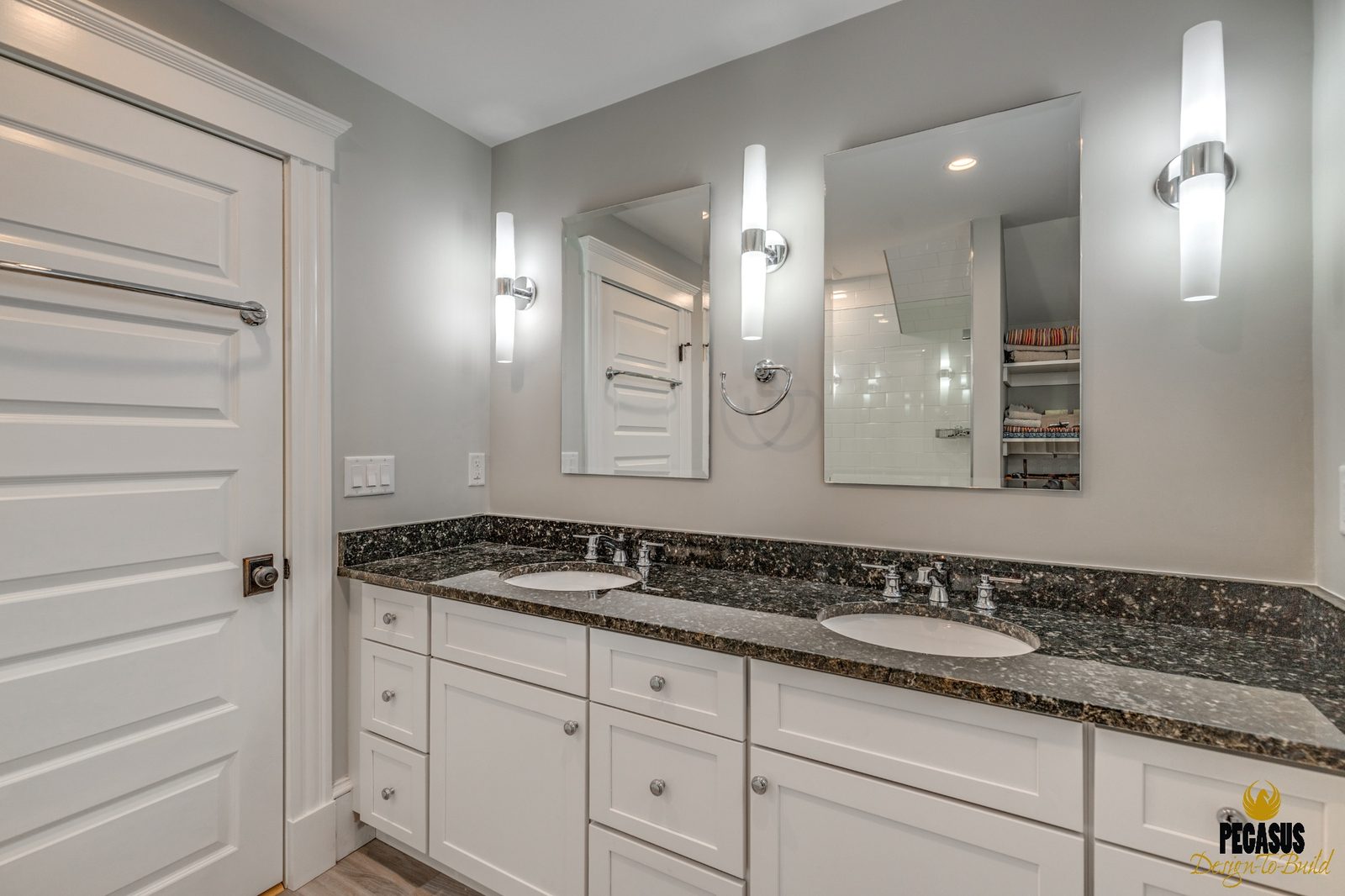 Bathroom with double-sink granite vanity, white cabinets and wall sconces in Arlington, MA