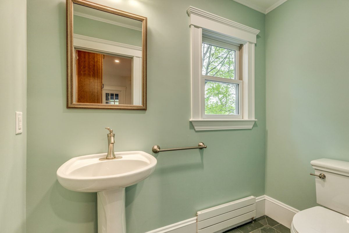 After: Powder room: the cramped half bath off the kitchen moved into the back entry as a bright new powder room with a pedestal sink.