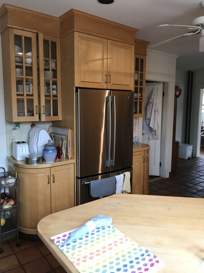 Before: Fridge wall: the same spot, rebuilt with cherry glass-front uppers and a full sink run under new windows.