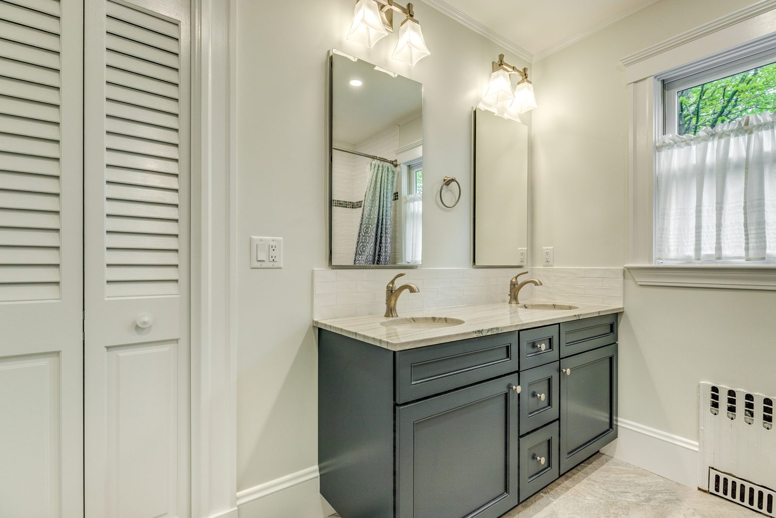 Remodeled second-floor bathroom in Arlington, MA with a blue-gray double vanity and marble top