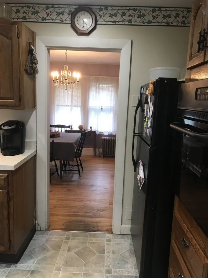 Before: Kitchen to dining room: a narrow doorway became a wide-open run of rustic alder cabinets and oak floor straight through to the dining area.