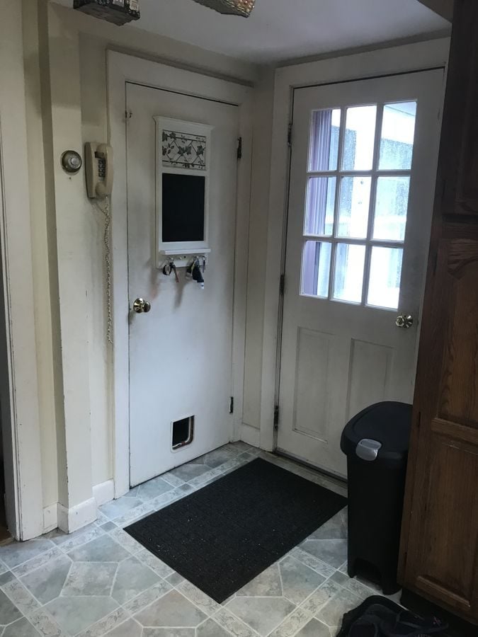 Before: Back entry: the cramped back door off the kitchen moved into a new mudroom addition with beadboard walls, a tile floor and a closet.