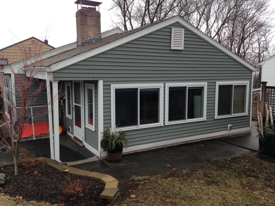 Before: Back corner: the one-story family room wing stayed, and the new second story with its gables and transom windows now rises behind it.