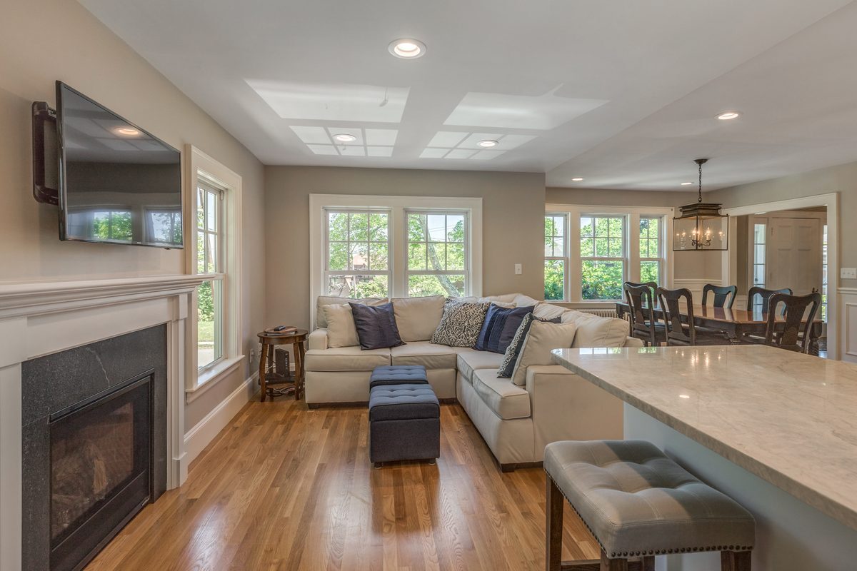 After: Family room: the step-down sunroom got a reframed level ceiling, a gas fireplace and an open connection to the kitchen.