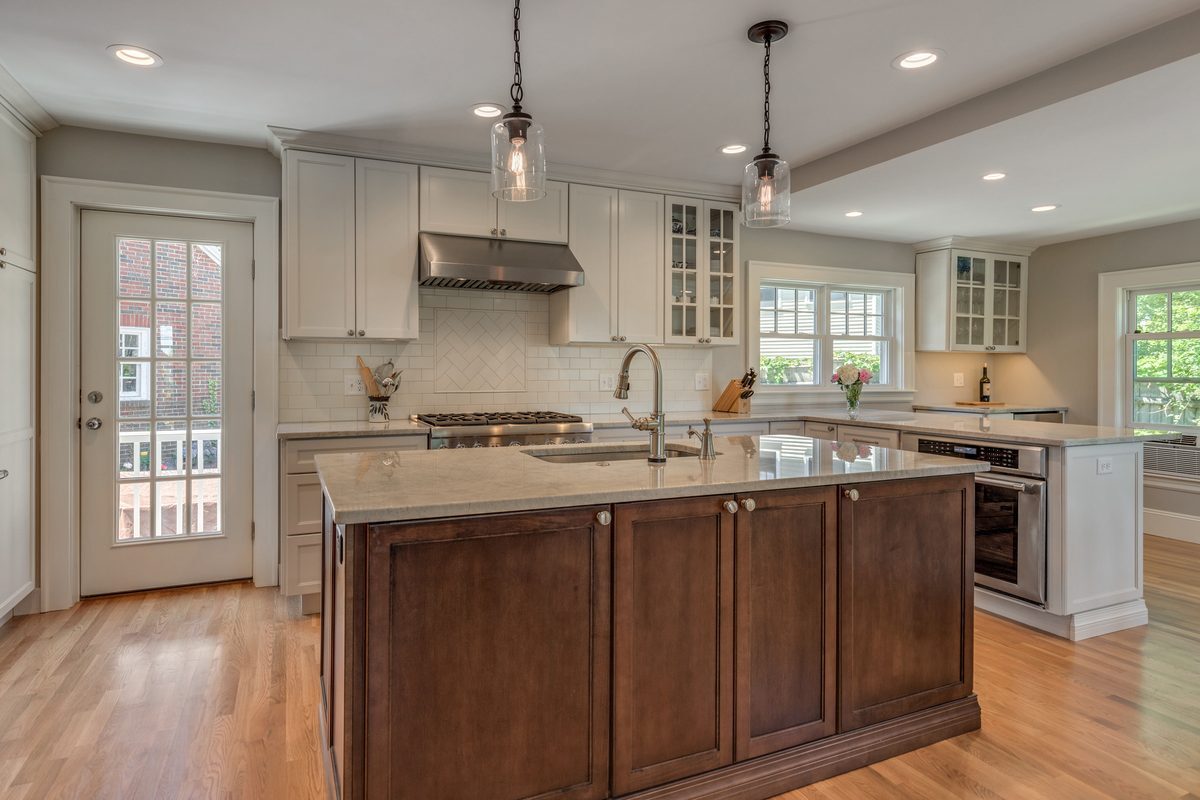 After: Kitchen: the old electric range by the back door gave way to a full-glass door to the new deck, a pro-style gas range and a subway backsplash with a herringbone panel.