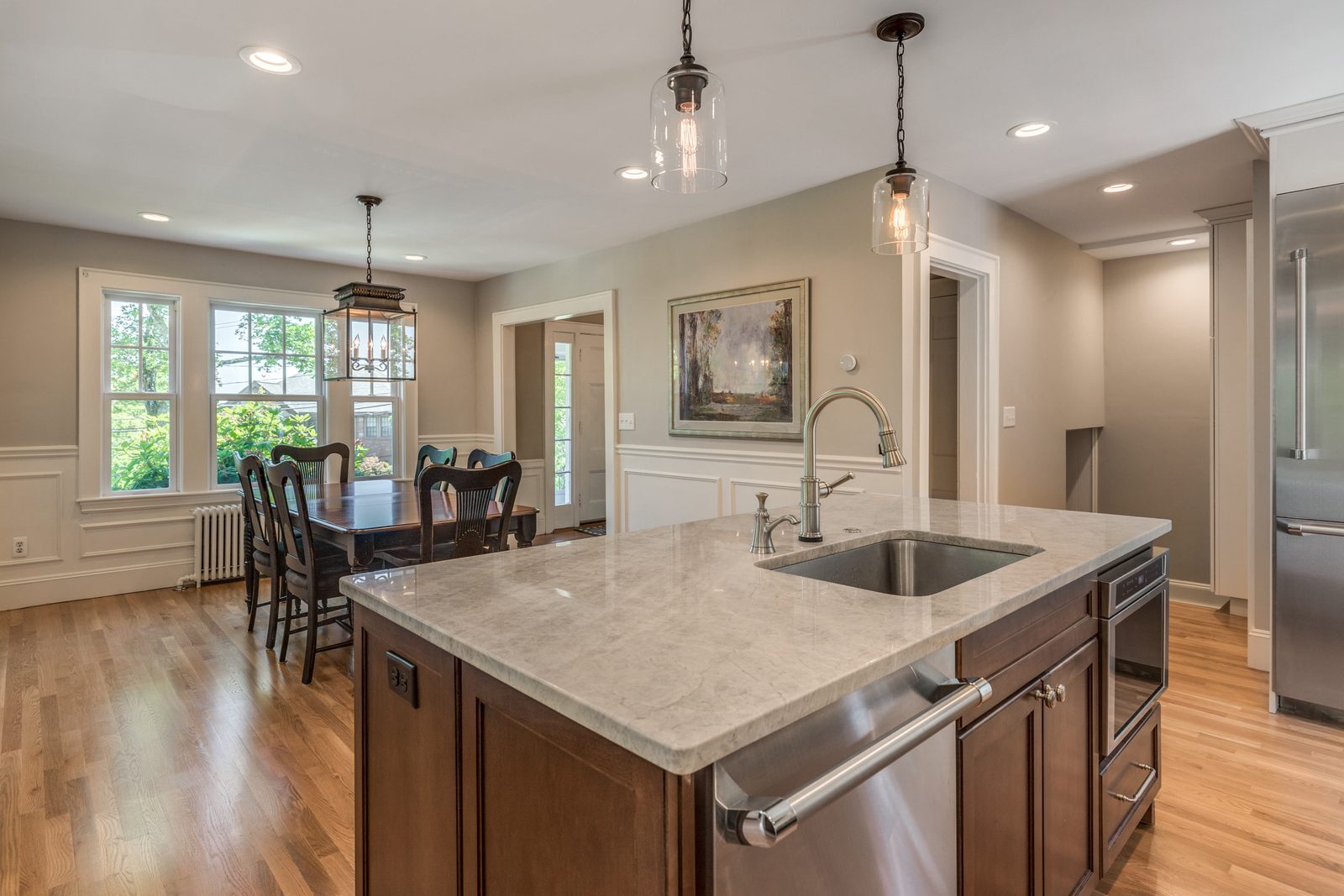 Kitchen island in Belmont, MA looking into the dining room with wainscoting and a lantern light