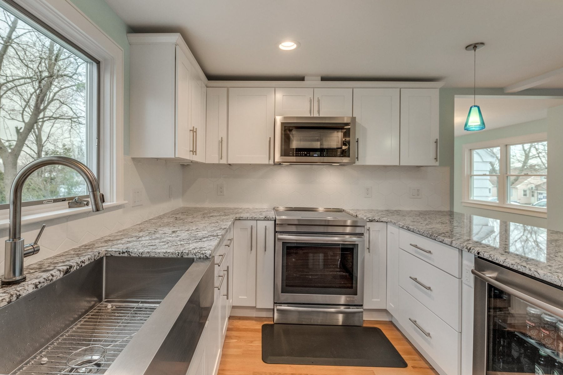 Kitchen corner with apron-front sink, hexagon tile backsplash and stainless range in Belmont, MA