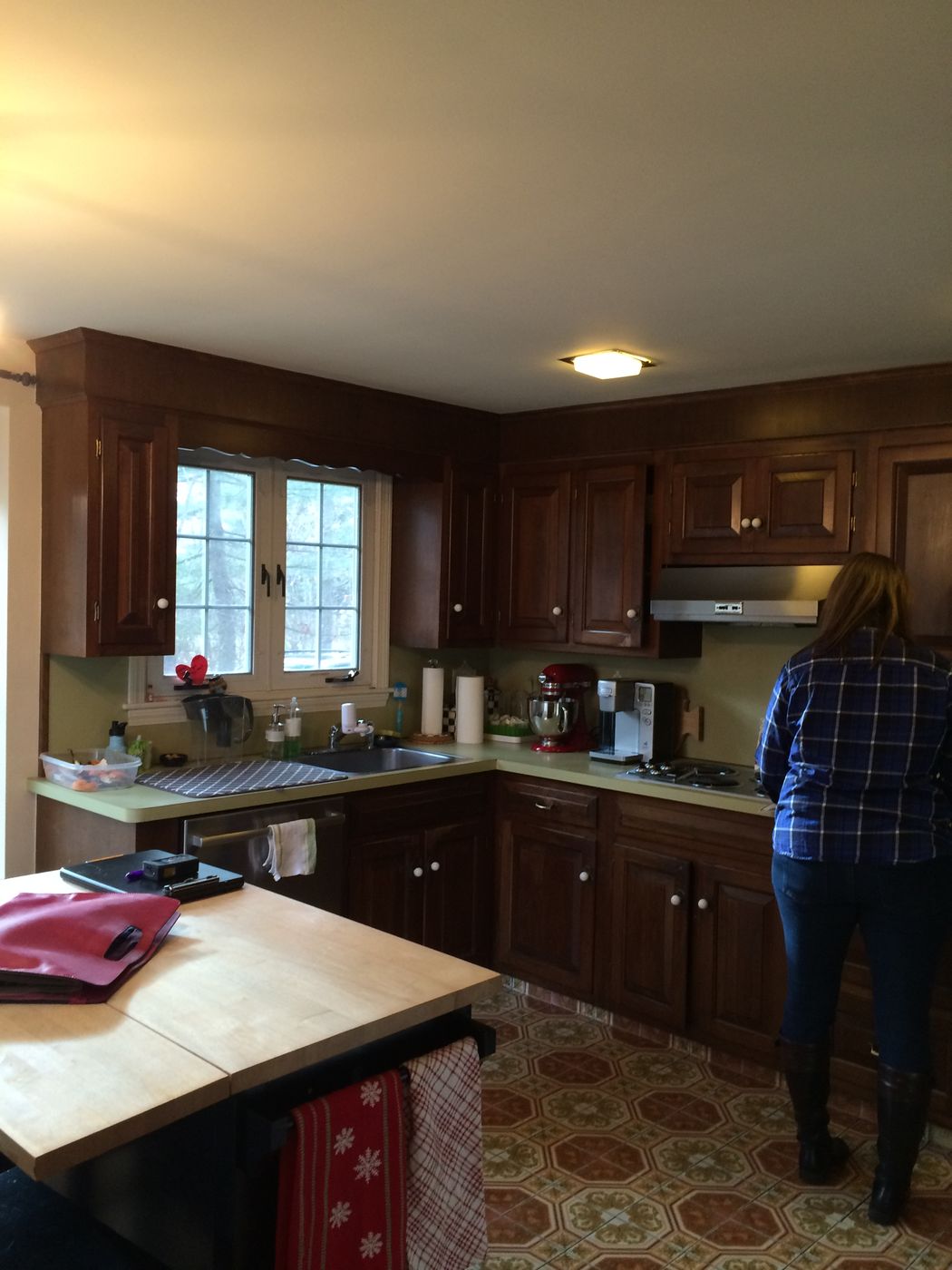 Before: Kitchen: dark raised-panel cabinets, laminate counters and a counter cooktop became white shaker cabinets, white granite, a gas range under a chimney hood and a long island.