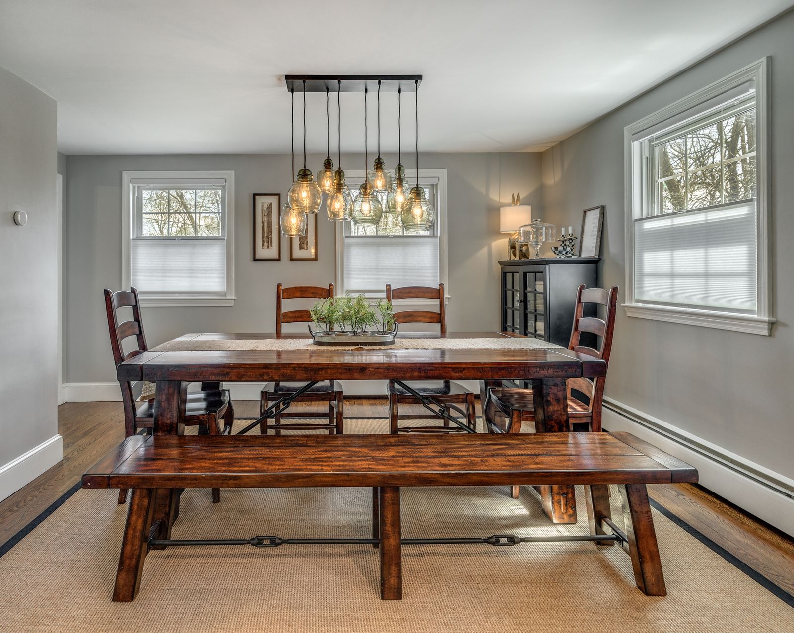 Dining room with a trestle table, bench and multi-pendant light
