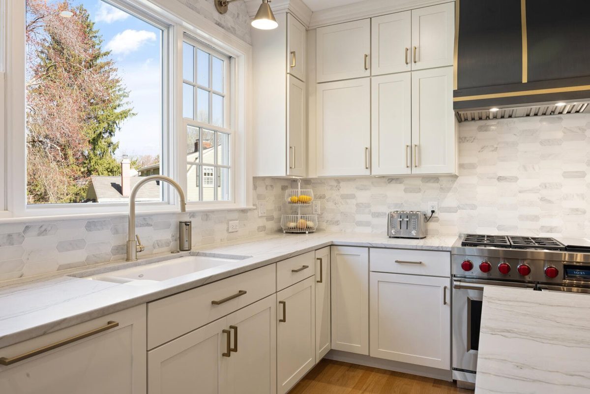 After: Kitchen: the old layout with a cooktop island became an open kitchen with a range wall and two sinks.